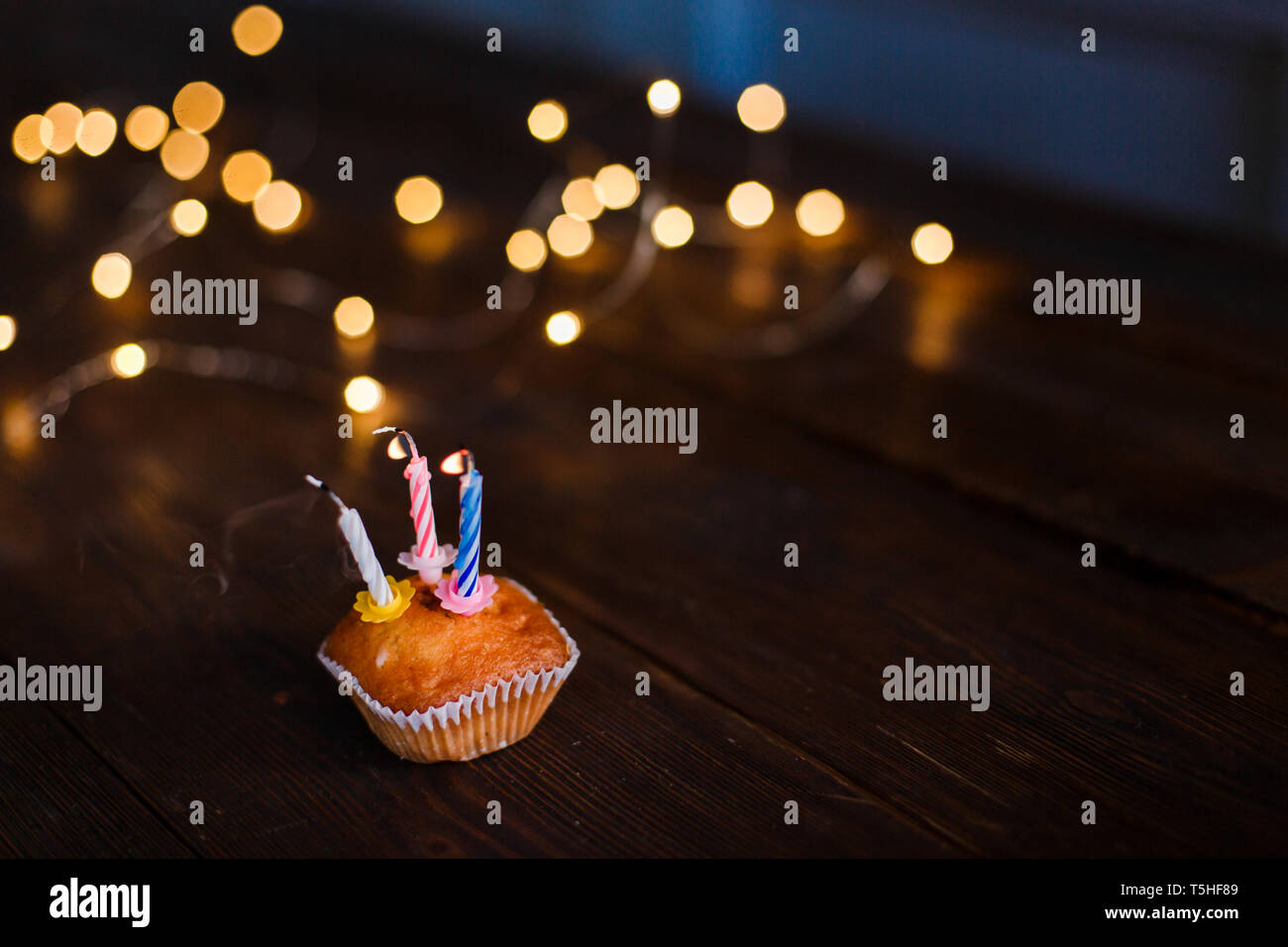 Bougies dans un petit gâteau pour une maison de vacances. Le concept d'une carte d'anniversaire de fête. Souffler les bougies, brûler des bougies avec de l'espace pour le texte. Belle salutation Banque D'Images