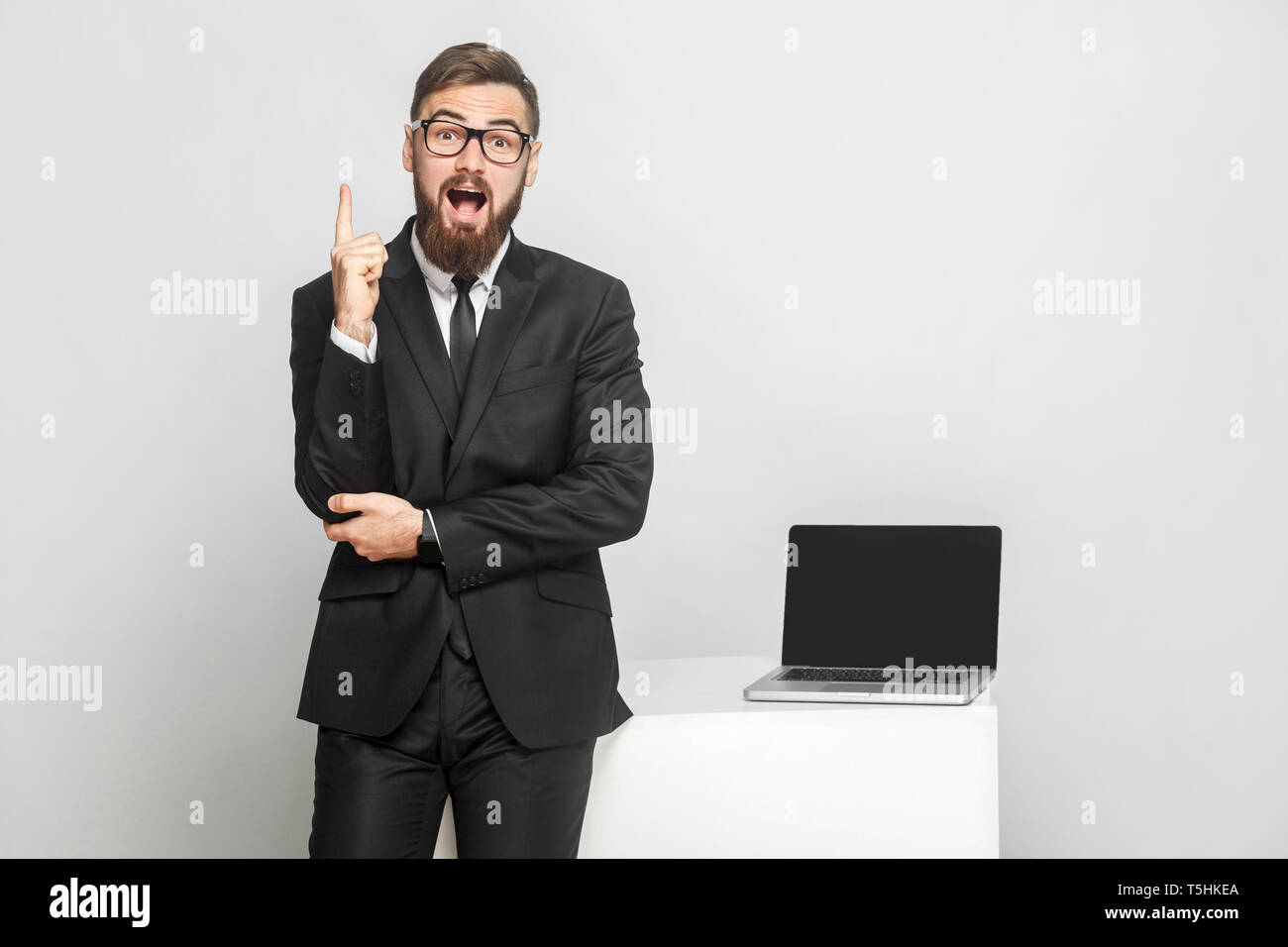 Nouvelle idée ! Portrait of handsome surpris bearded businessman sont debout près de son lieu de travail et montrant doigt vers le haut avec mo Banque D'Images