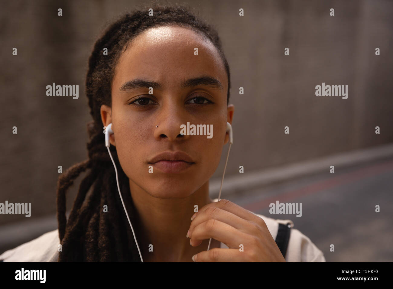 Jeune femme à l'écoute de la musique sur le casque dans la rue Banque D'Images Jeune femme à l'écoute de la musique sur le casque dans la rue Banque D'Images
