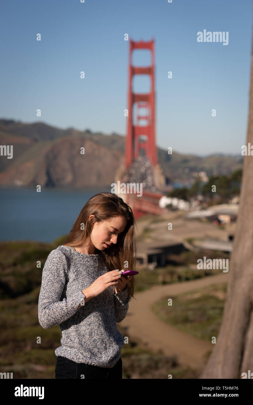 Beautiful woman using mobile phone while standing Banque D'Images Beautiful woman using mobile phone while standing Banque D'Images