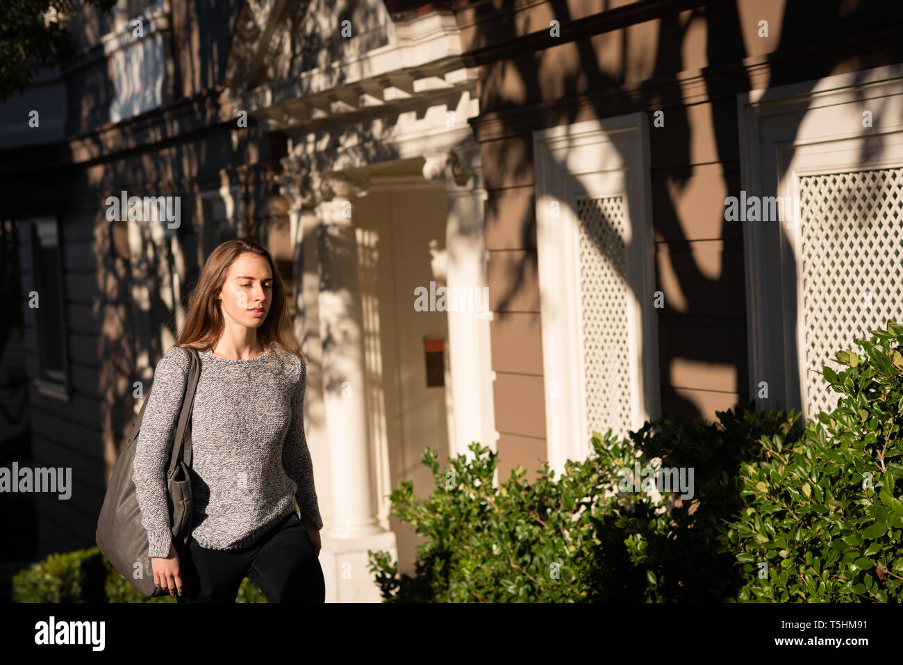 Femme marche sur rue sur une journée ensoleillée Banque D'Images