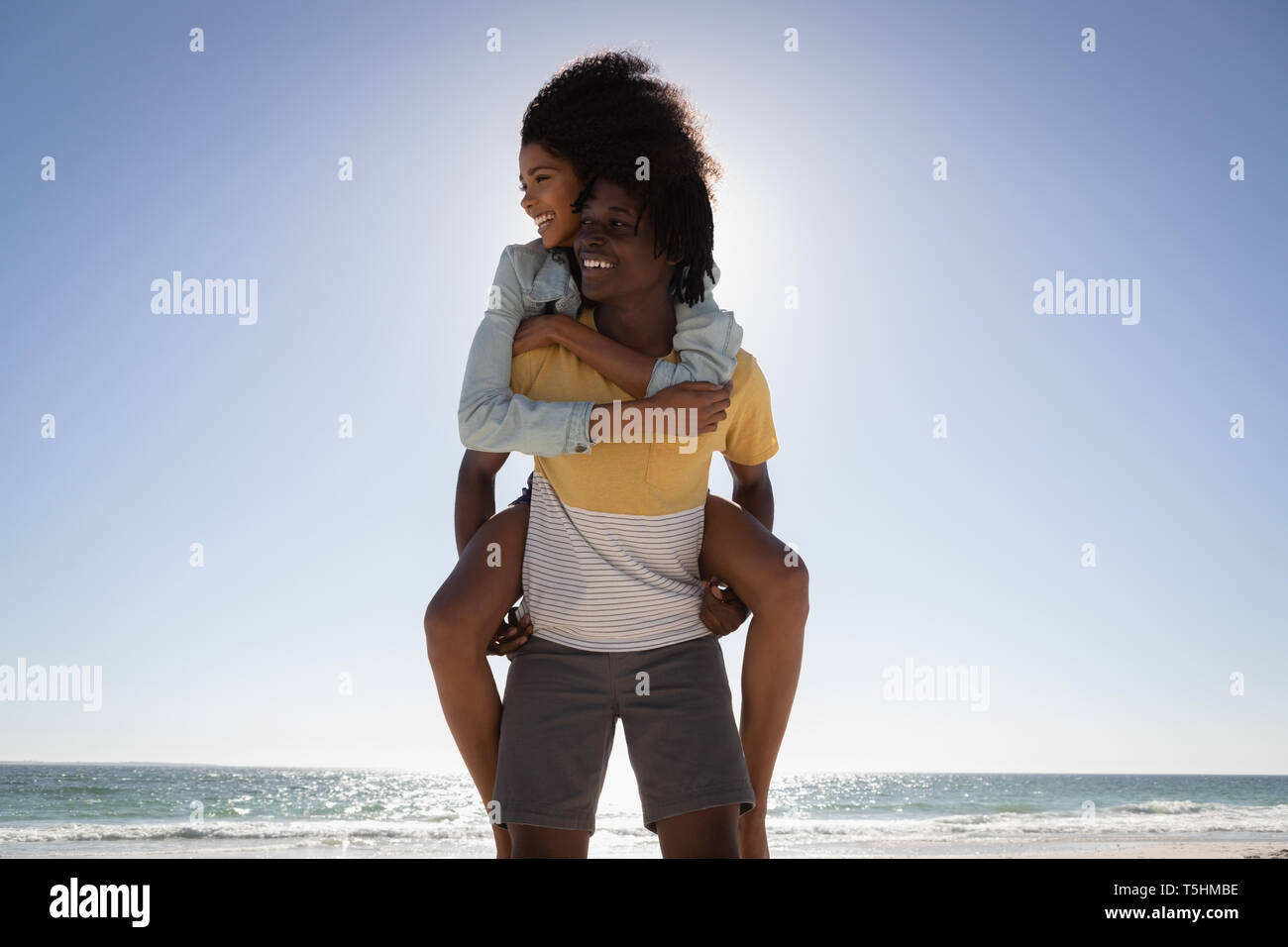Young man giving woman piggyback at beach Banque D'Images Young man giving woman piggyback at beach Banque D'Images