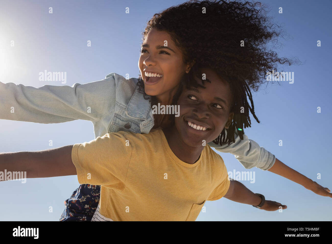 Young man giving woman piggyback at beach Banque D'Images Young man giving woman piggyback at beach Banque D'Images