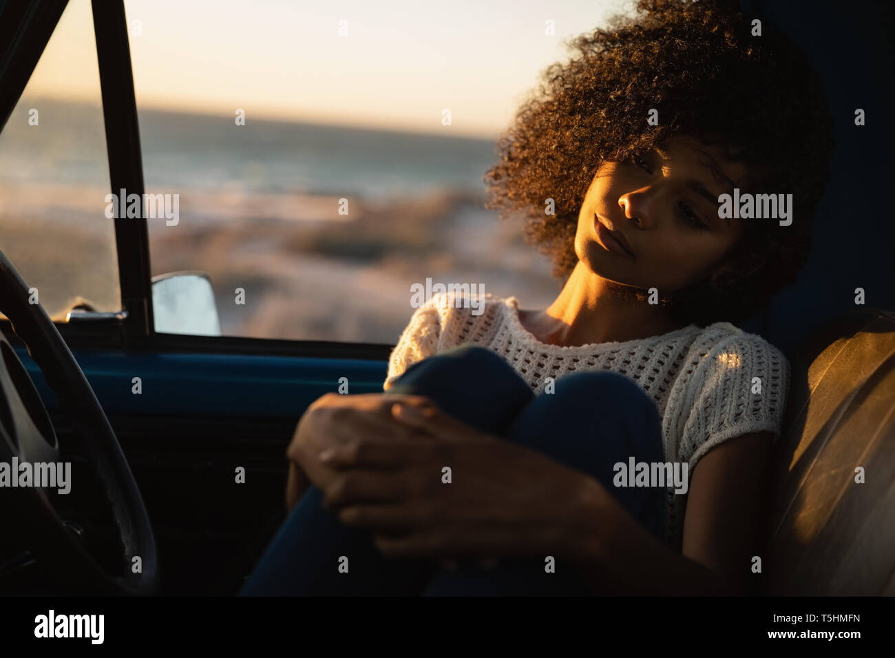 Beautiful woman sitting in car at beach Banque D'Images Beautiful woman sitting in car at beach Banque D'Images