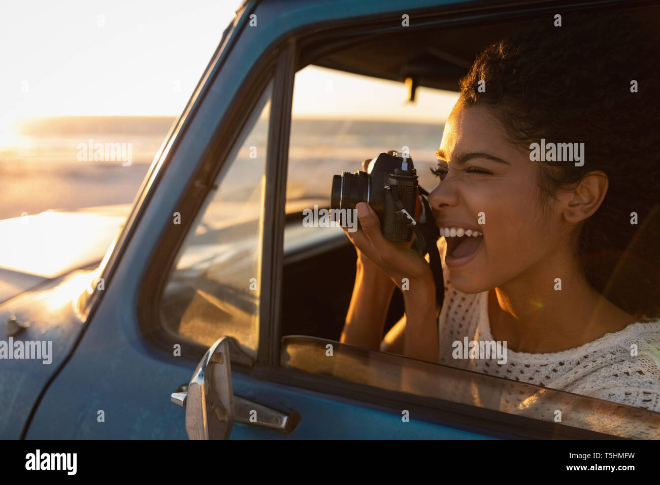 Belle femme prendre des photos avec l'appareil photo dans la voiture Banque D'Images Belle femme prendre des photos avec l'appareil photo dans la voiture Banque D'Images