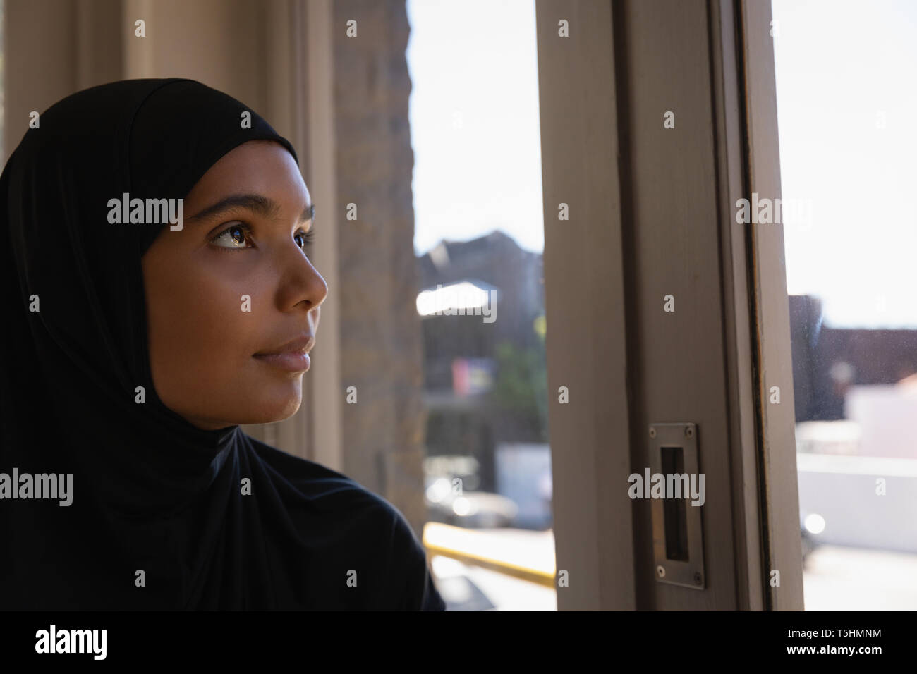 Jeune femme en hijab se détendre dans un café Banque D'Images Jeune femme en hijab se détendre dans un café Banque D'Images