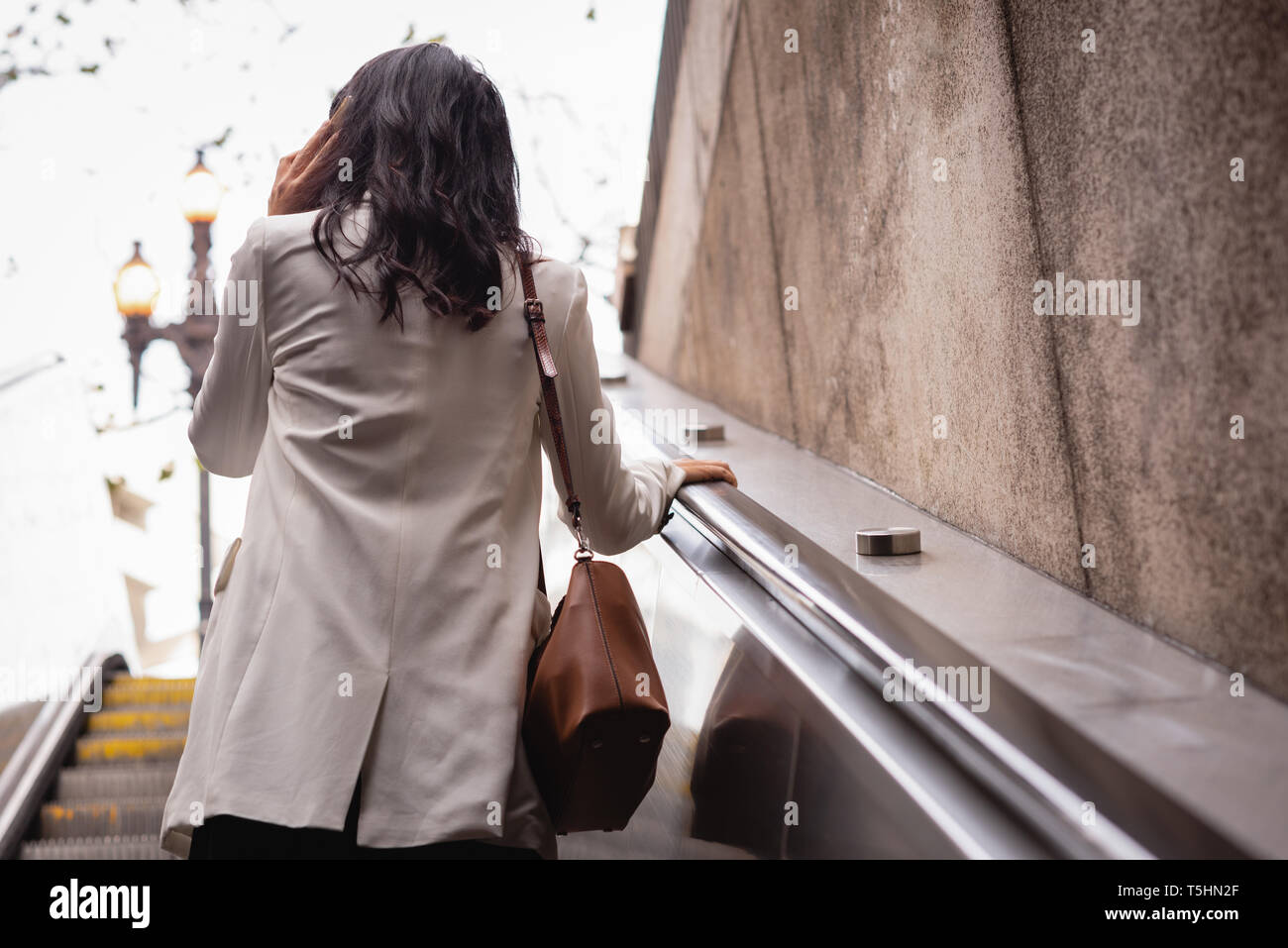 Woman talking on mobile phone on escalator Banque D'Images Woman talking on mobile phone on escalator Banque D'Images