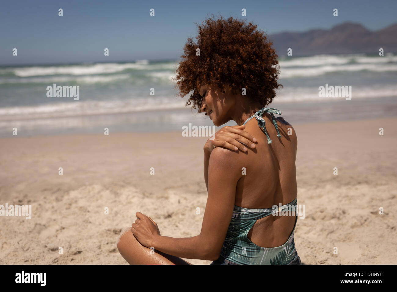 Woman putting lotion écran solaire sur le long d'une plage à Banque D'Images Woman putting lotion écran solaire sur le long d'une plage à Banque D'Images