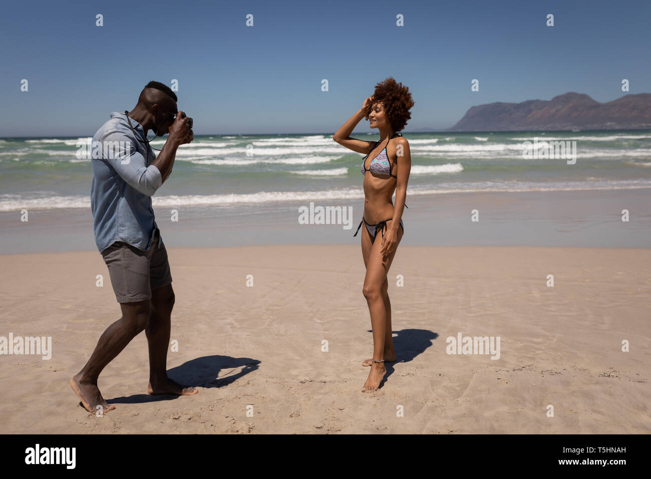 L'homme en cliquant sur la photo d'une femme avec un appareil photo numérique à la plage Banque D'Images L'homme en cliquant sur la photo d'une femme avec un appareil photo numérique à la plage Banque D'Images