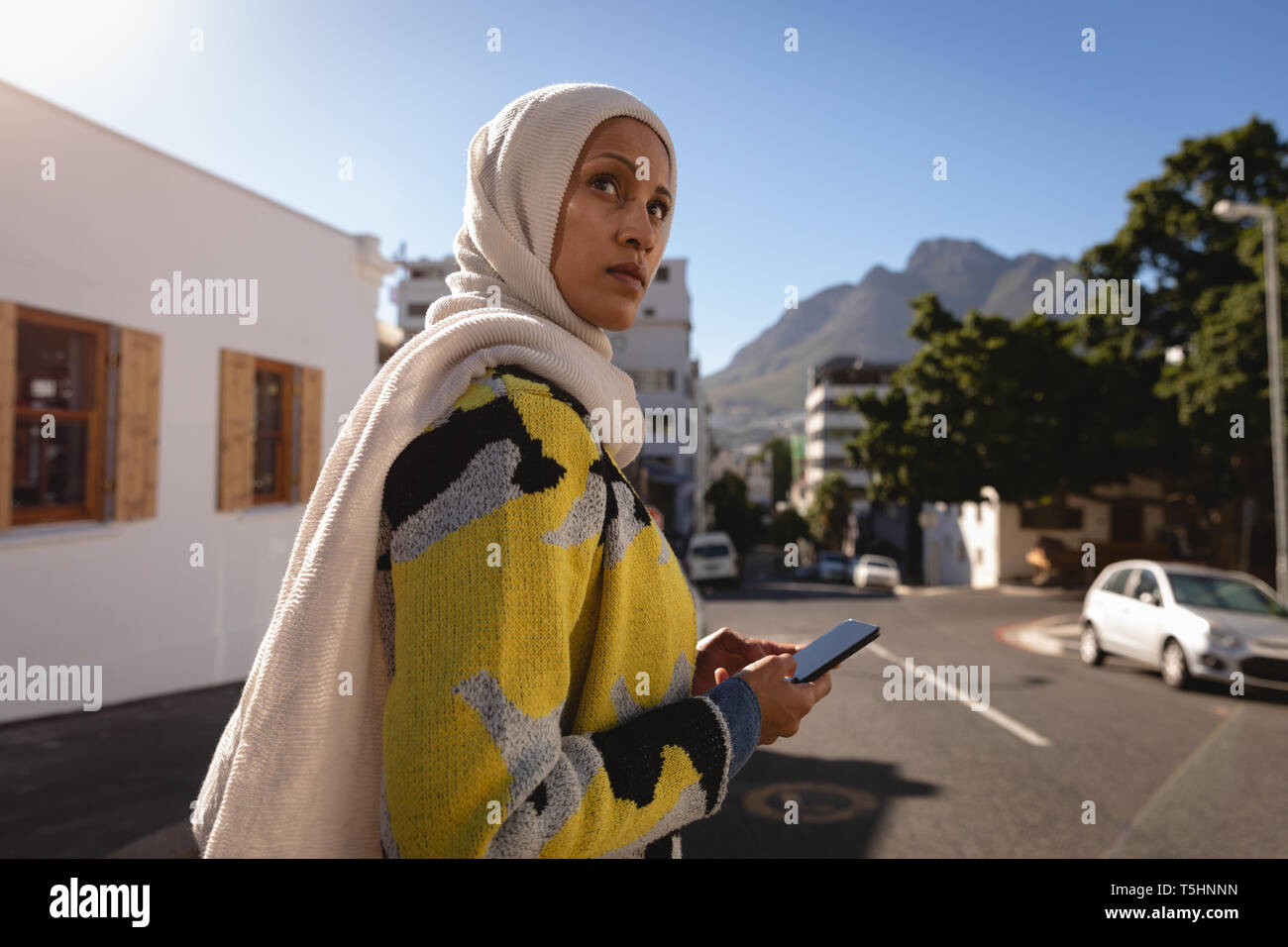 Woman using mobile phone en étant debout dans la rue Banque D'Images Woman using mobile phone en étant debout dans la rue Banque D'Images