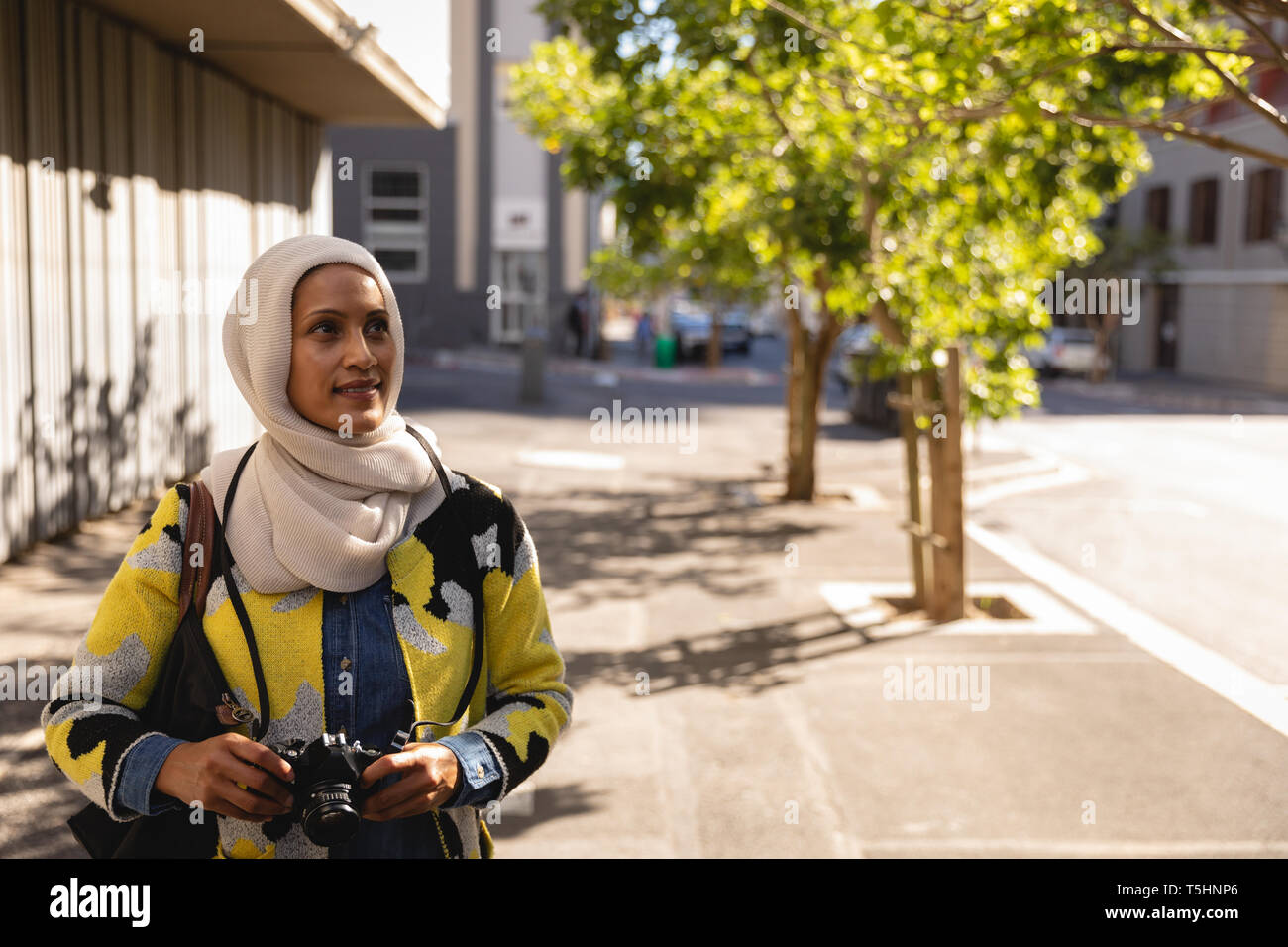 Young woman standing on street with digital camera Banque D'Images Young woman standing on street with digital camera Banque D'Images
