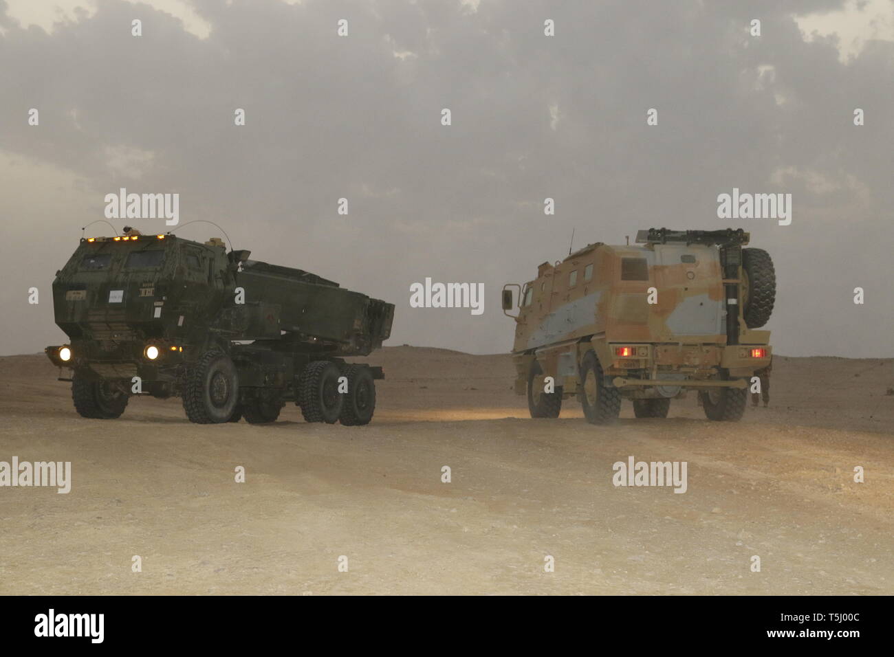 La saturation du système de fusées d'artillerie du Qatar et de l'artillerie américaine High-Mobility système fusée de lancement pour un projet commun de scène live-le-feu avec les États-Unis à Umm Hawta, Qatar, le 3 avril 2019. À l'appui de soldats Spartan Task Force stationnée au Koweït a pris son envol avec deux High-Mobility Système d'artillerie de lanceurs. Les membres de Bravo Batterie, 5e Bataillon, 113e, d'artillerie de la Garde nationale de Caroline du Nord s'est rendu dans un C-17 de l'Armée de l'air de l'Émir du Qatar à la terre au Qatar et tirer dans le cadre d'un live-le-feu avec les forces terrestres de l'Émir du Qatar qui ont tiré leurs ASTROS pendant l'exercice Al Adheed 20 Banque D'Images