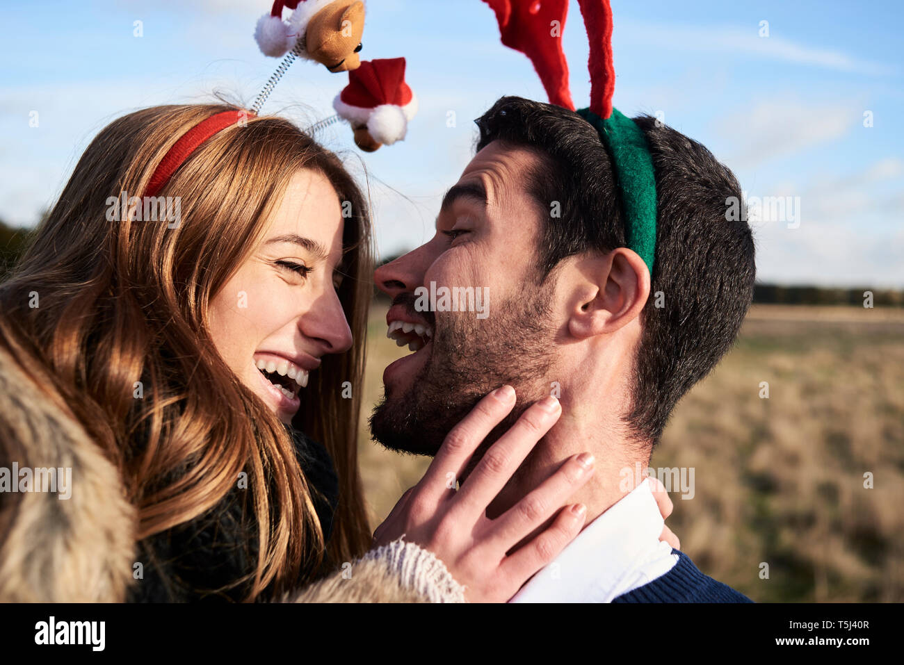 Happy carefree couple wearing headdress Noël à la campagne Banque D'Images