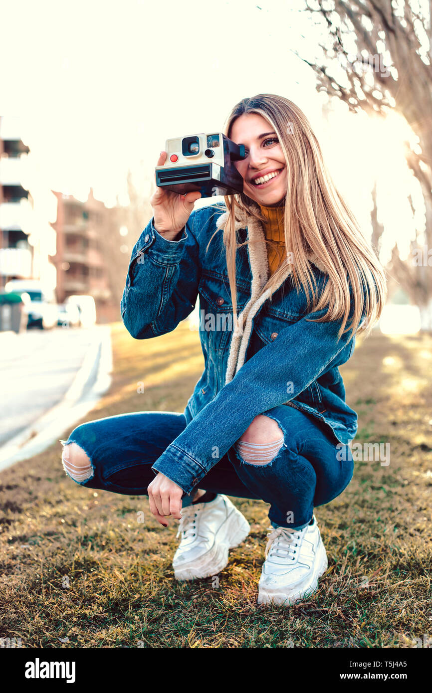 Portrait de jeune femme à l'aide de l'appareil photo instantané Banque D'Images