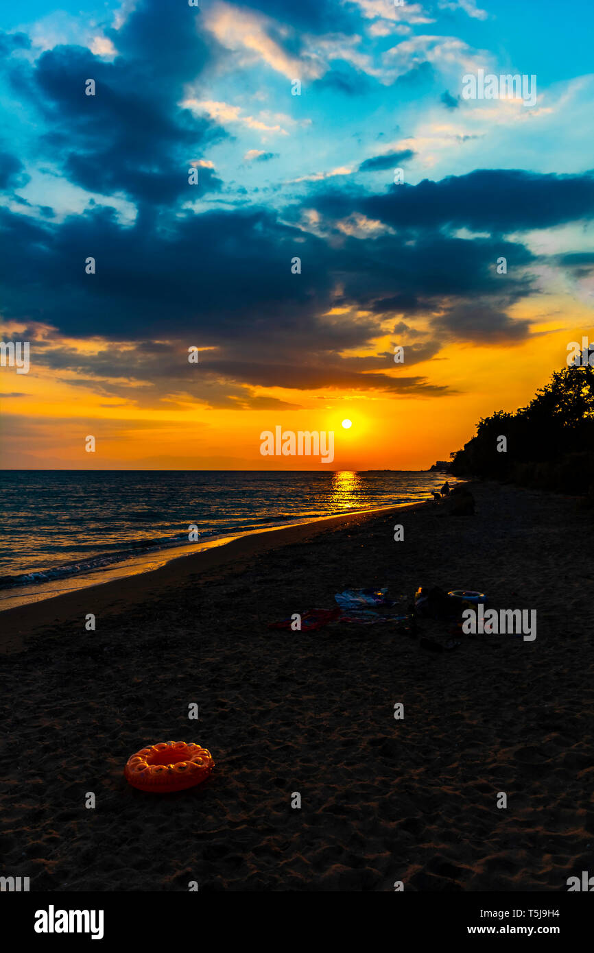 Côte de soleil vertical mer calme avec golden sun clouds - Fin de l'après-midi sur la plage de flottaison avec coucher du soleil calme mer océan ciel dramatique nuages cloudscap Banque D'Images