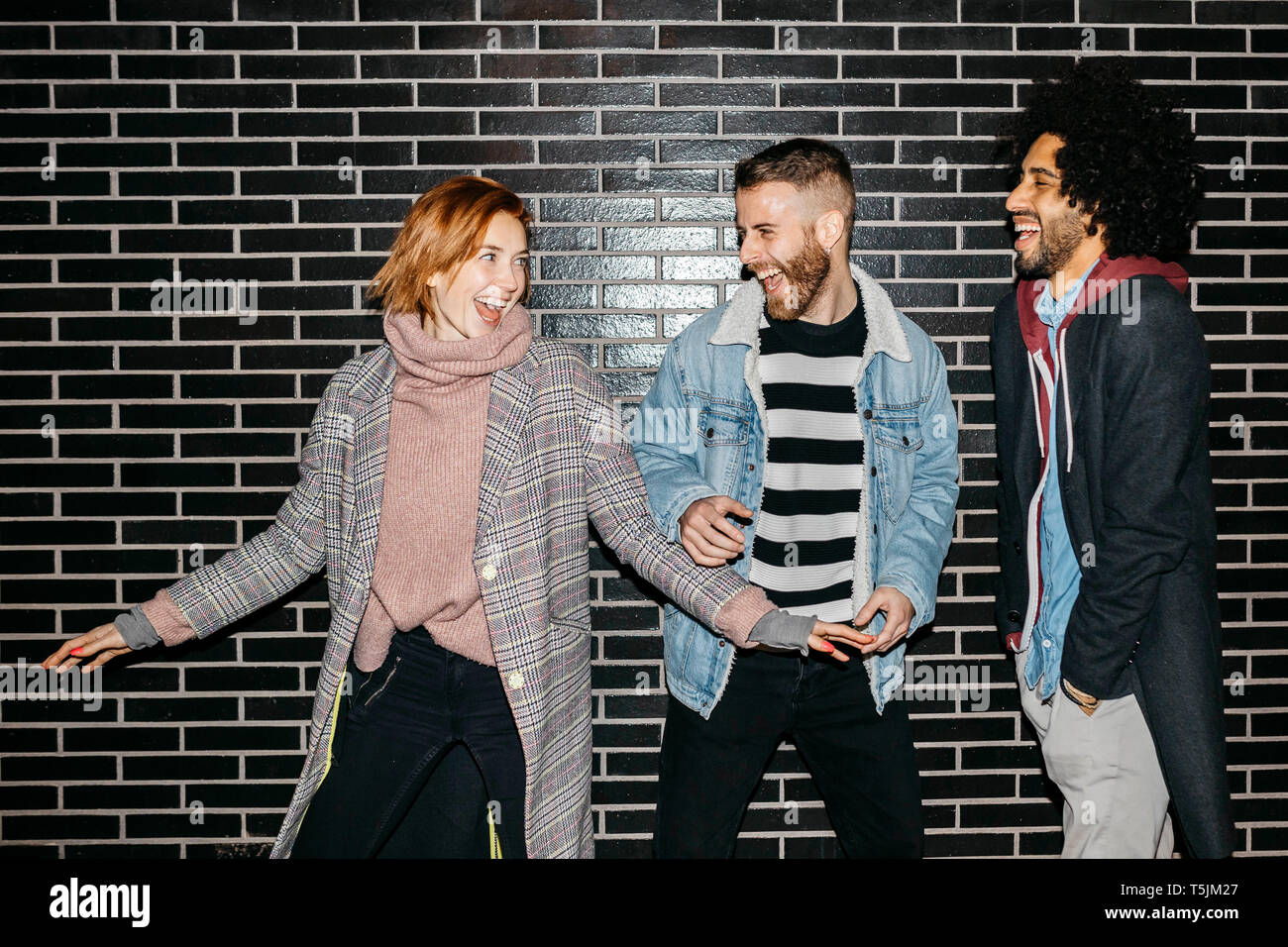 Trois amis lors d'une amusante heureux mur noir Banque D'Images