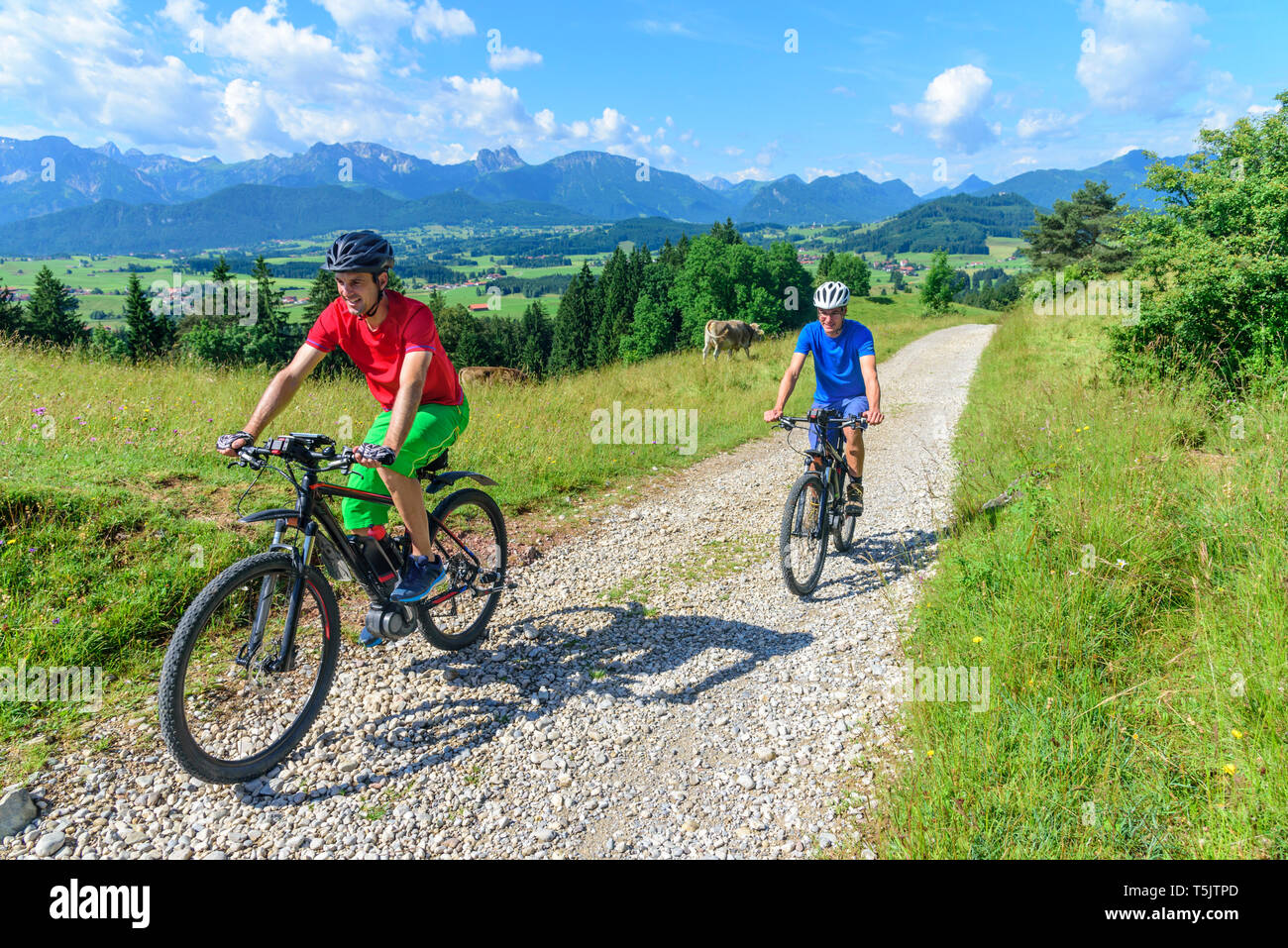 Deux hommes à vélo avec des vélos électriques sur route de gravier dans l'Est de l'Allgäu Banque D'Images