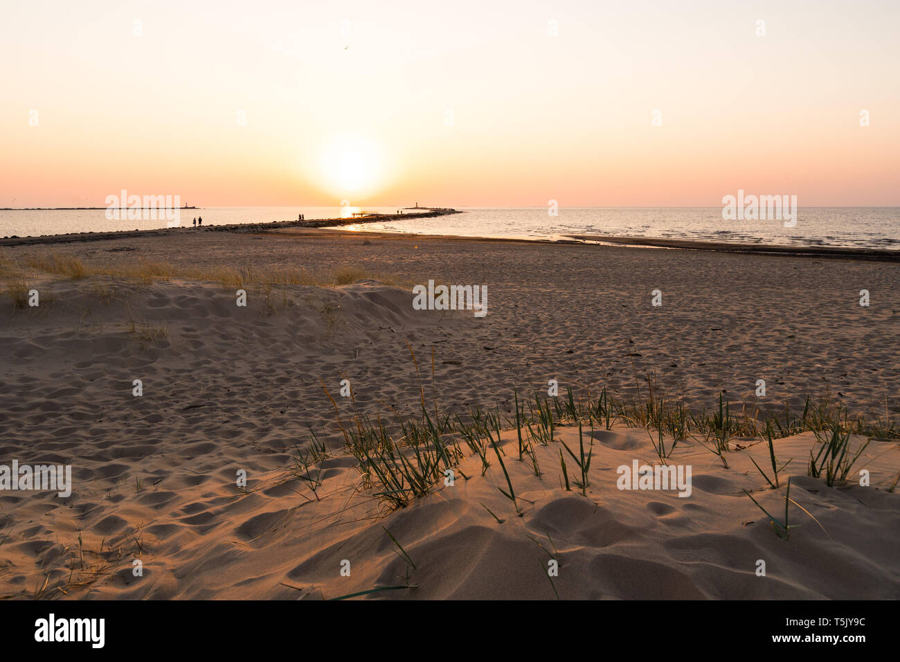 Leuchtturm lors d'une dernière minute de coucher du soleil avec un grand soleil près de l'horizon et ciel clair Banque D'Images