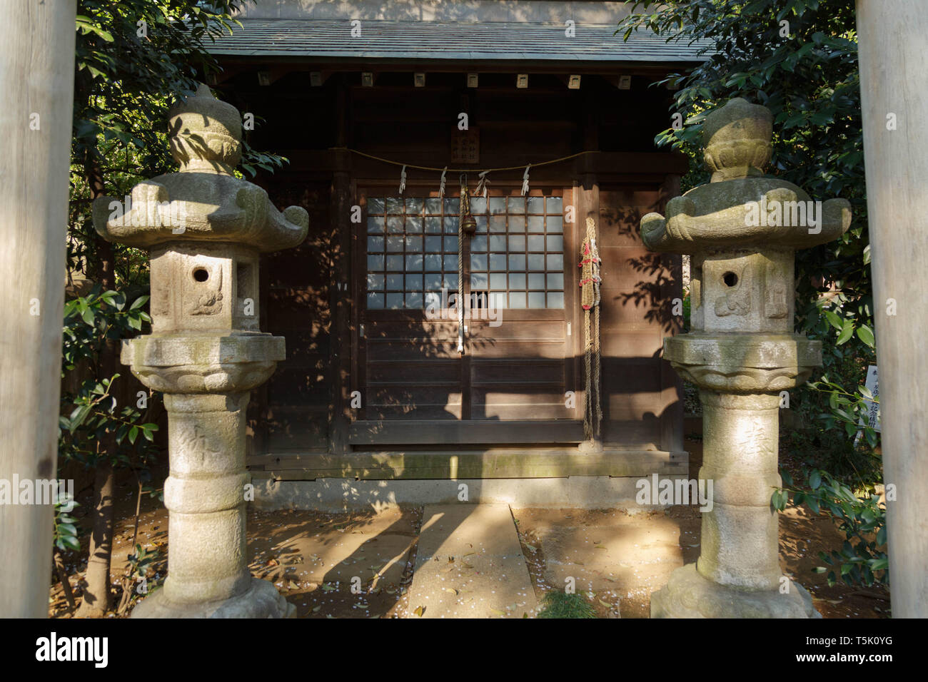 Un petit adorant l'annexe avec deux lanternes - pierre debout sur la face derrière le torii à Maginu culte, Kawasaki. Le Japon. Banque D'Images