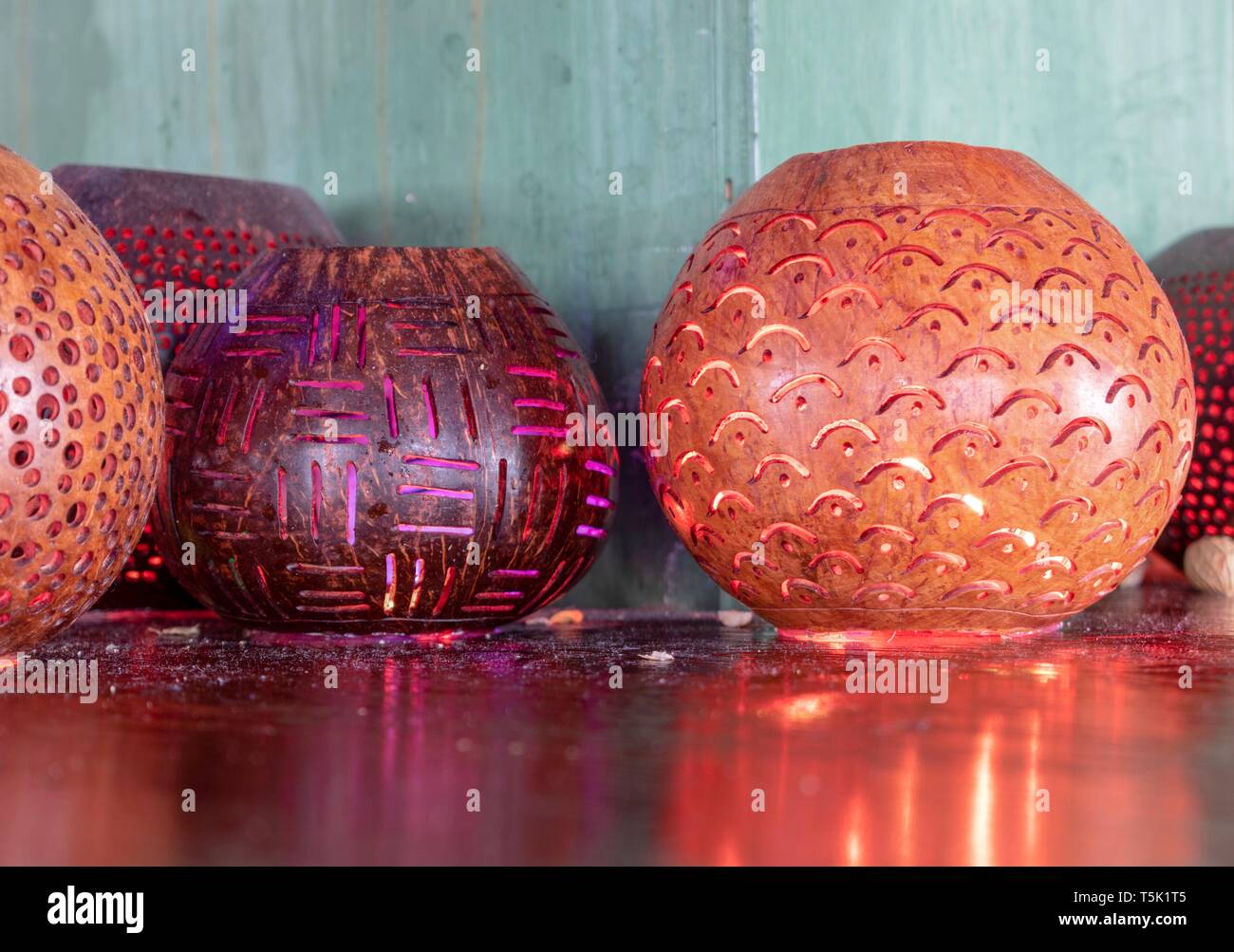 Bougies décoratives colorées reflétant des bols sur la surface d'une table en bois brillant haut Banque D'Images