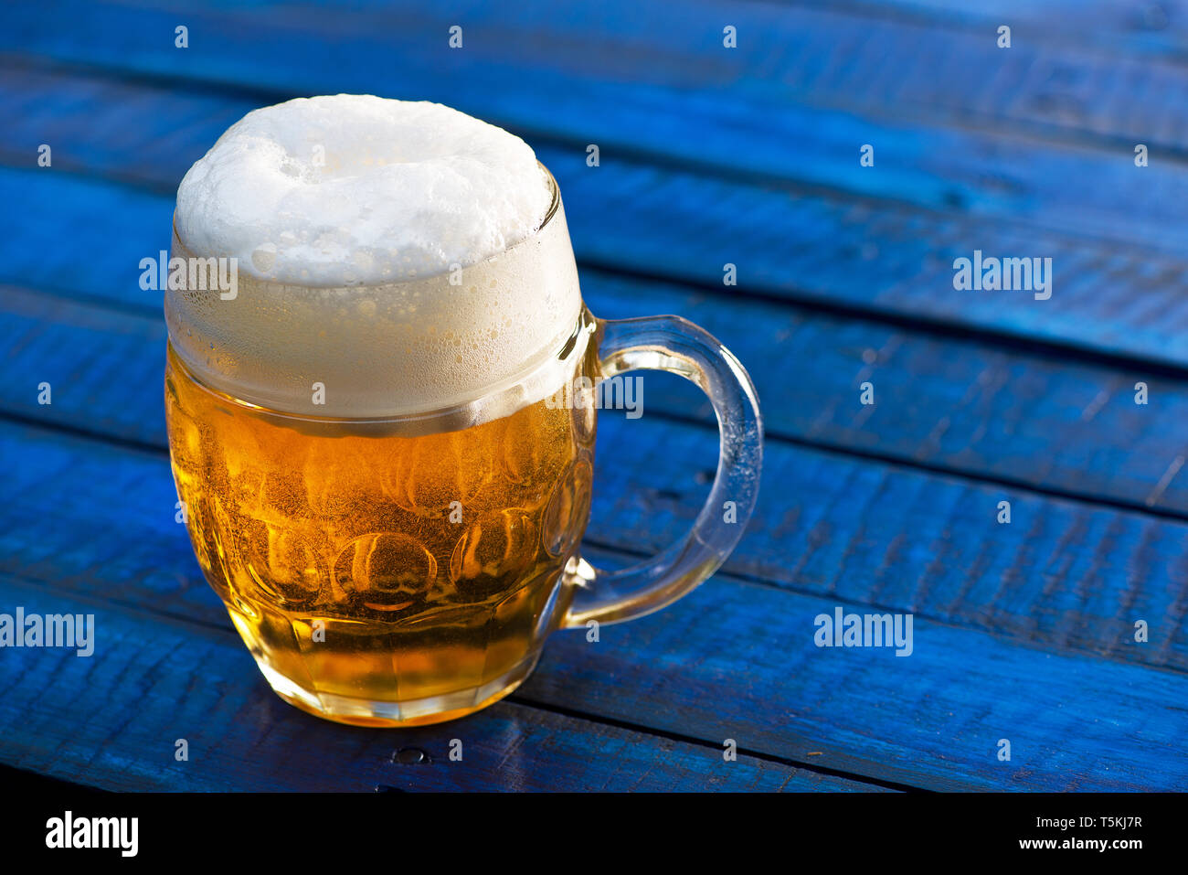 Verre de bière sur le fond en bois bleu. Banque D'Images