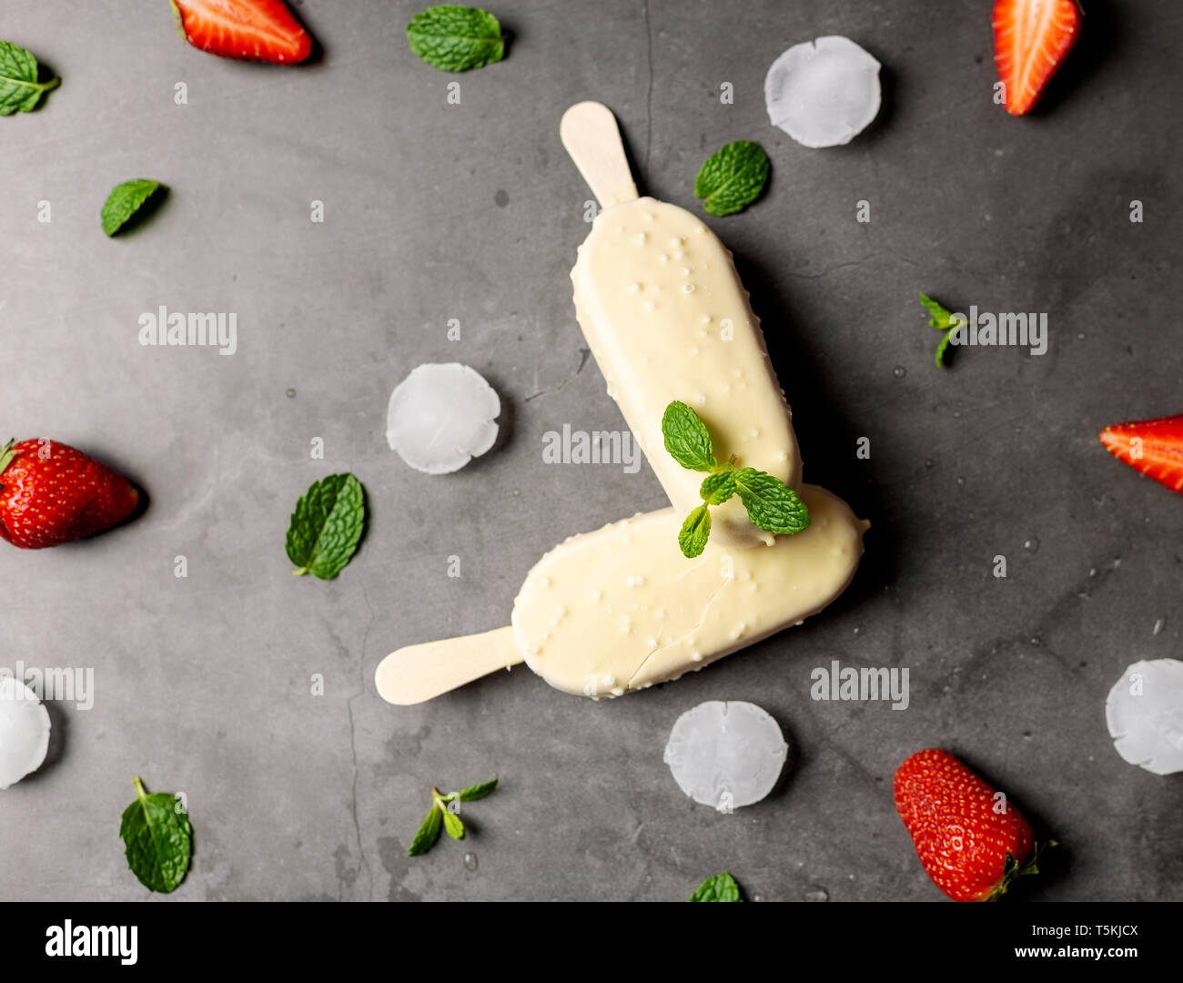 La crème glacée fraise stick recouvert de chocolat blanc, glace , sur noir table de marbre, télévision lay Banque D'Images