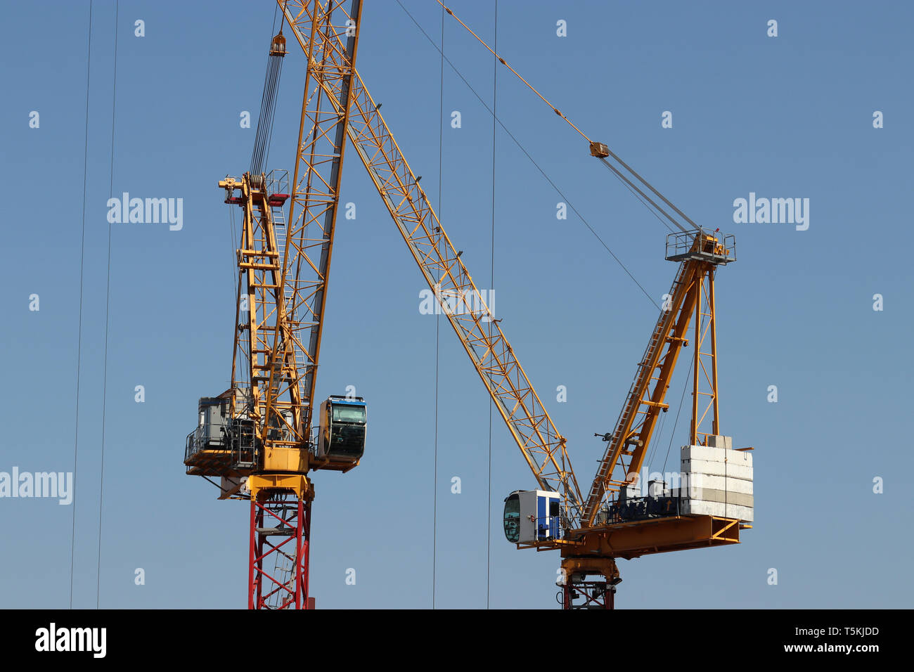 Les grues de construction isolé sur fond de ciel bleu clair. Concept de la construction de logements ou les travaux de chargement de marchandises Banque D'Images