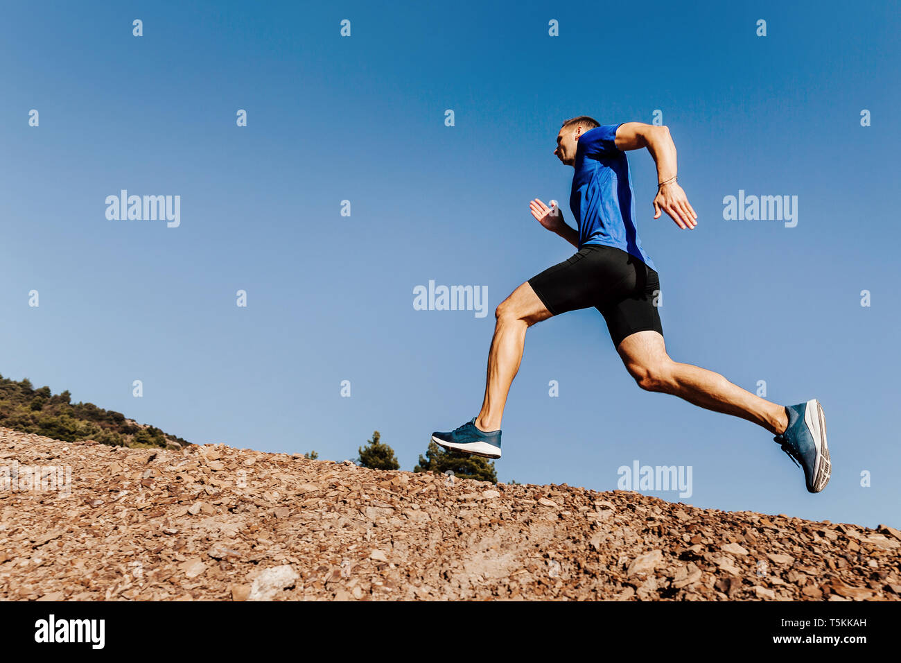 Coureur athlète courir vers le sentier sur fond de ciel bleu Banque D'Images