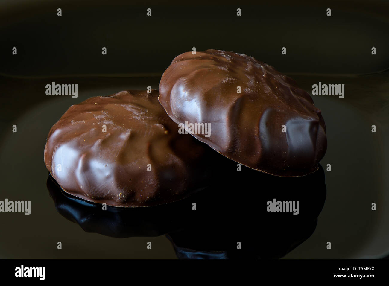 Glaçage au chocolat à la guimauve sur fond noir avec la réflexion. Close up Banque D'Images