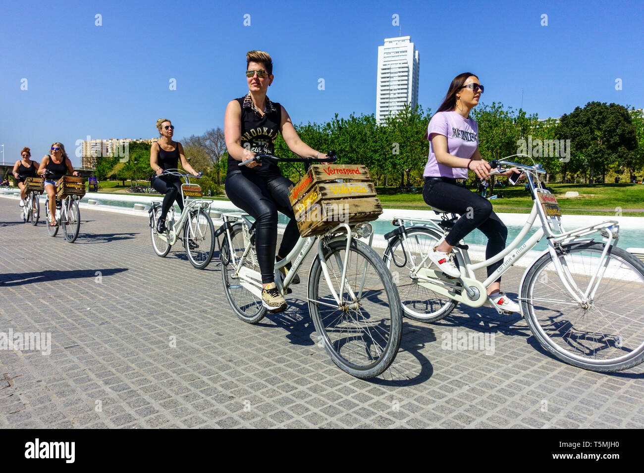 Les touristes font du vélo sur un vélo de location, les femmes font du vélo sur une piste cyclable à Valence Turia Park Espagne Bicycle City Europe piste cyclable Banque D'Images