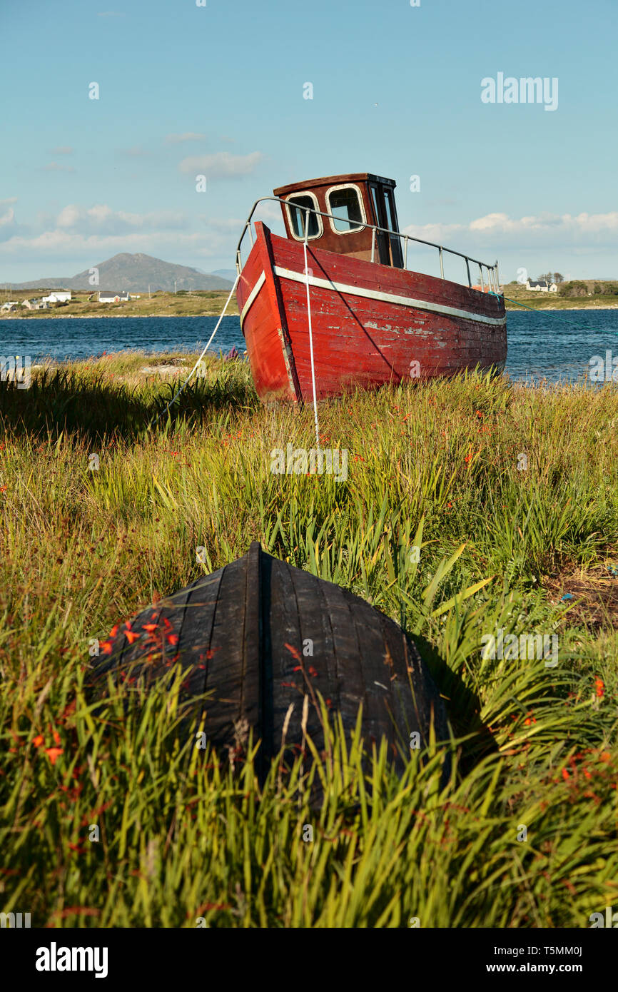 Un vieux bateau abandonné rouge dans Roundstone, l'Irlande qui est tombée en ruine. Le long de la manière sauvage de l'Atlantique de l'Irlande dans le Connemara west coas Banque D'Images