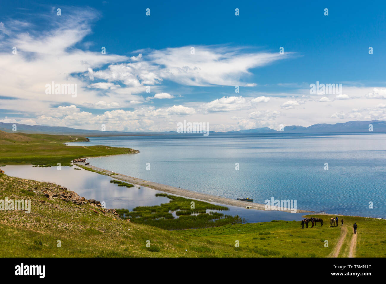 Un homme conduit une location en descente jusqu'à un magnifique lac de montagne. Chanson de montagne lac Kol. Kirghizistan Banque D'Images Un homme conduit une location en descente jusqu'à un magnifique lac de montagne. Chanson de montagne lac Kol. Kirghizistan Banque D'Images