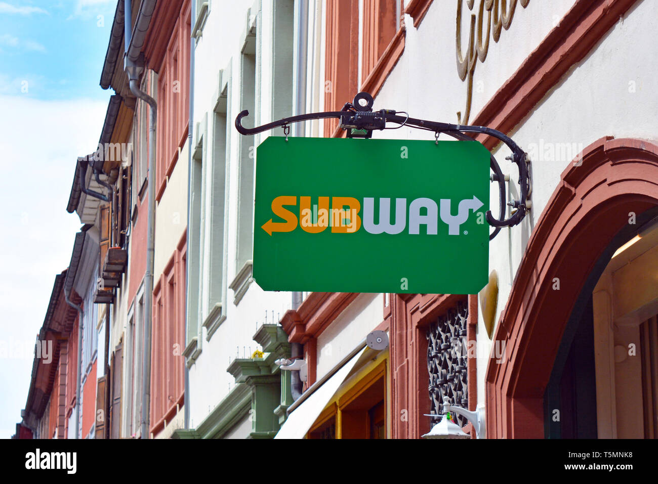 Hanging shop bannière avec logo de restaurant fast food franchise appelé le métro qui vend des sandwiches sous-marins et d'autres aliments avec vieux bui Banque D'Images