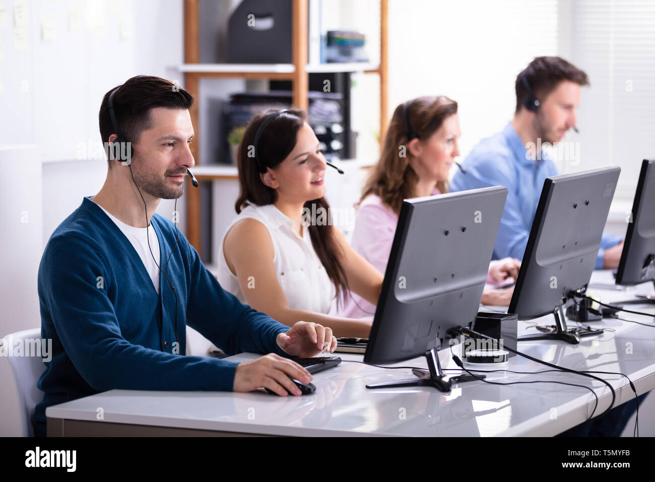 Heureux les jeunes cadres du Service Client à l'aide d'écouteurs travaillant dans Call Center Banque D'Images