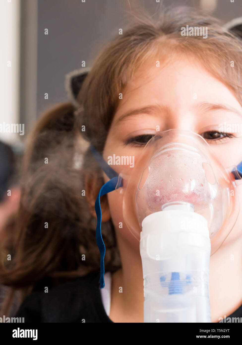 Petite fille l'inhalation avec masque à oxygène à la maison Banque D'Images