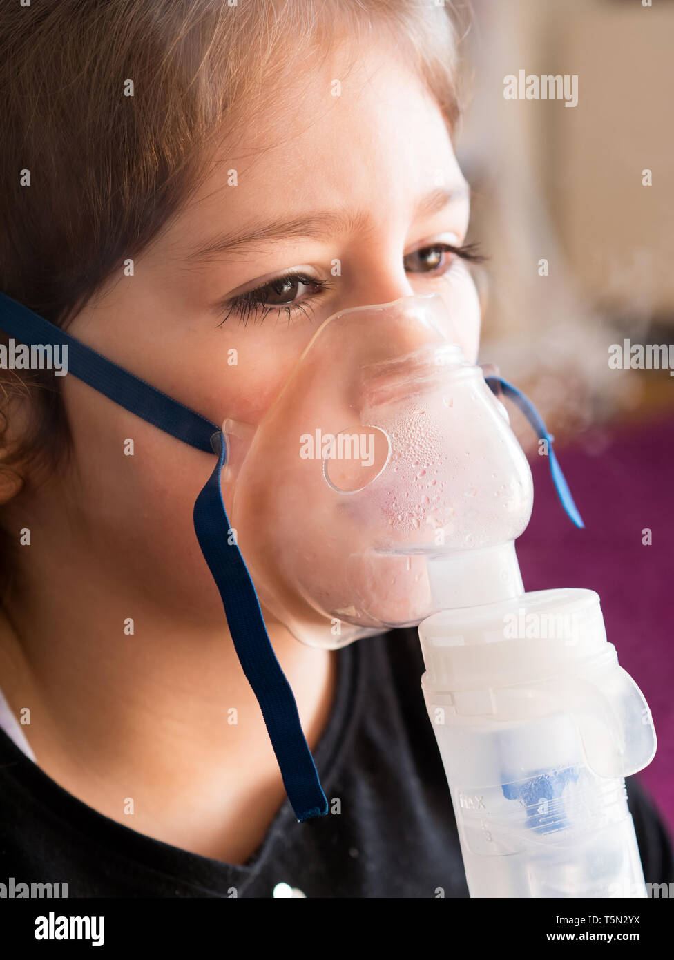 Petite fille de race blanche l'inhalation Inhalateur d'oxygène à la maison Banque D'Images