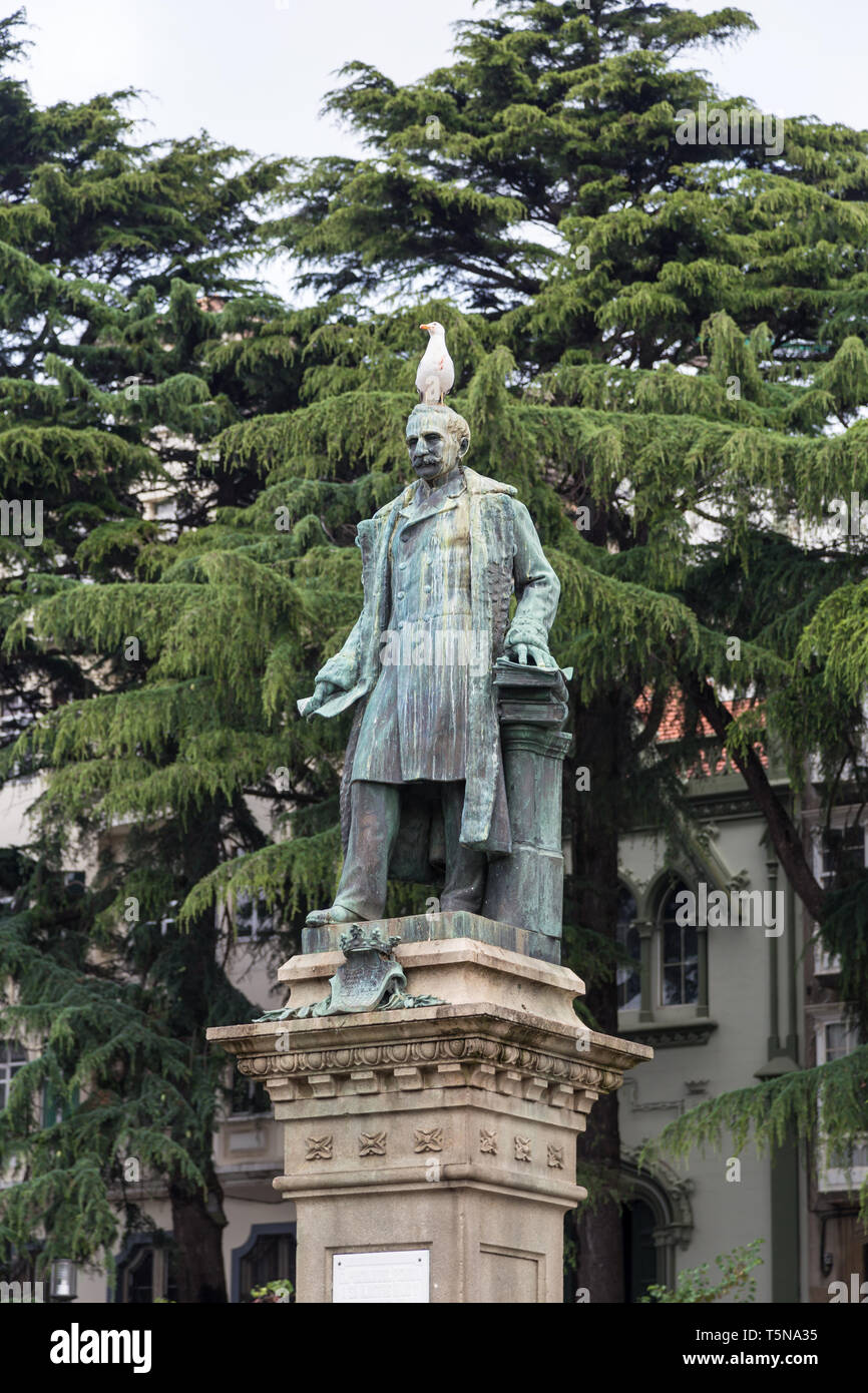 Statue d'un homme qui est éclairé lui vaut une mouette sur la tête Banque D'Images