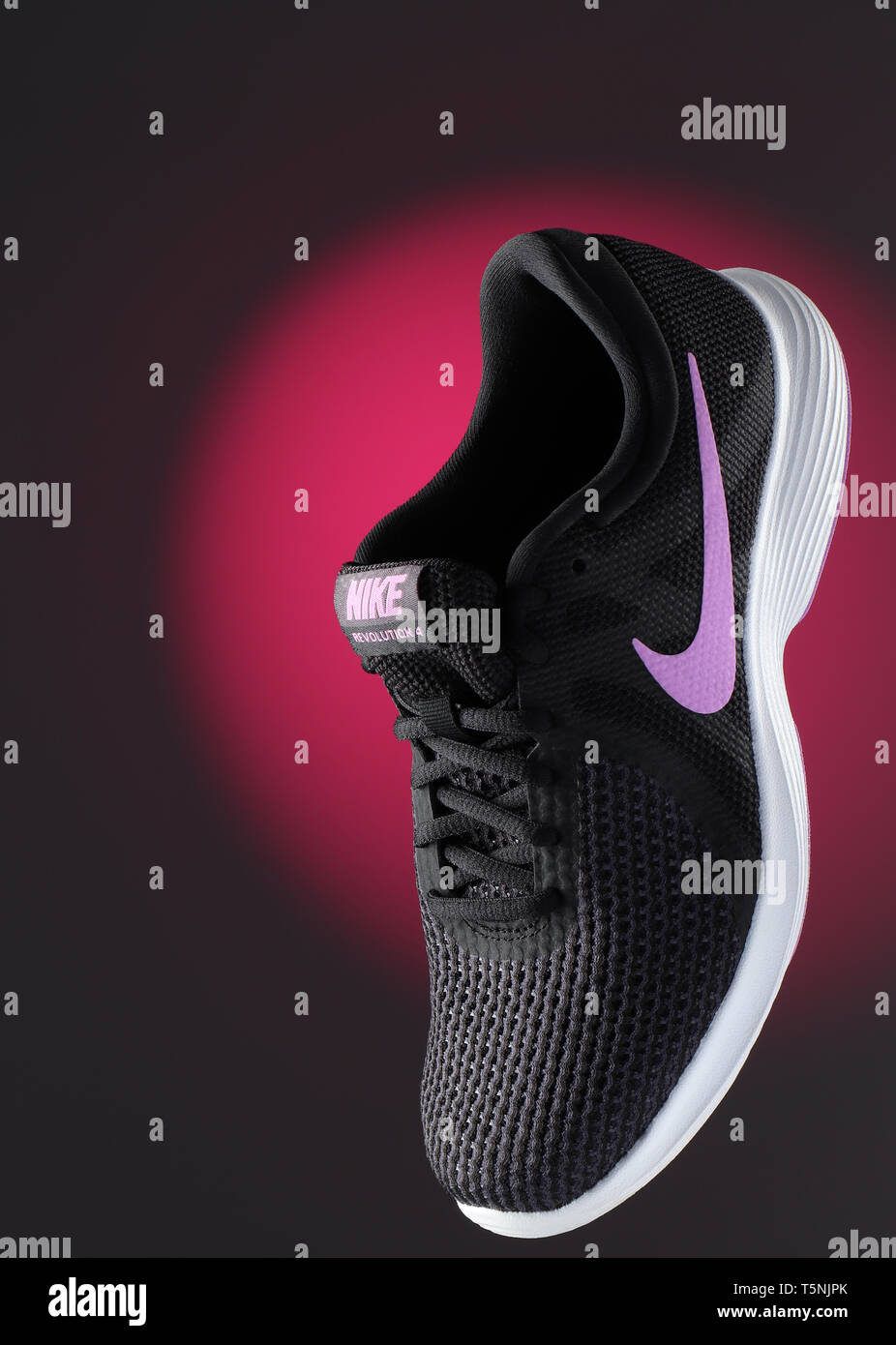 Encore une image de la vie d'une chaussure de sport Nike women's, flottant en face de fond violet Banque D'Images