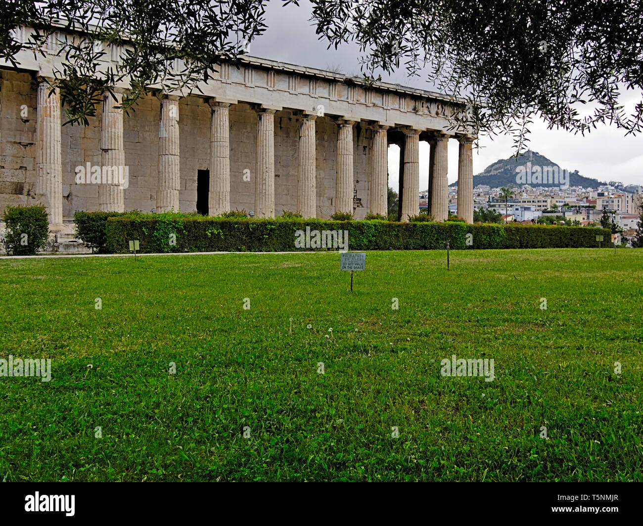 Temple d'Héphaïstos à Athènes, Grèce. L'herbe dans le premier plan avec le libellé 'o pas marcher sur l'herbe'. Le Lycabette et dans la zone de construction de ville Banque D'Images