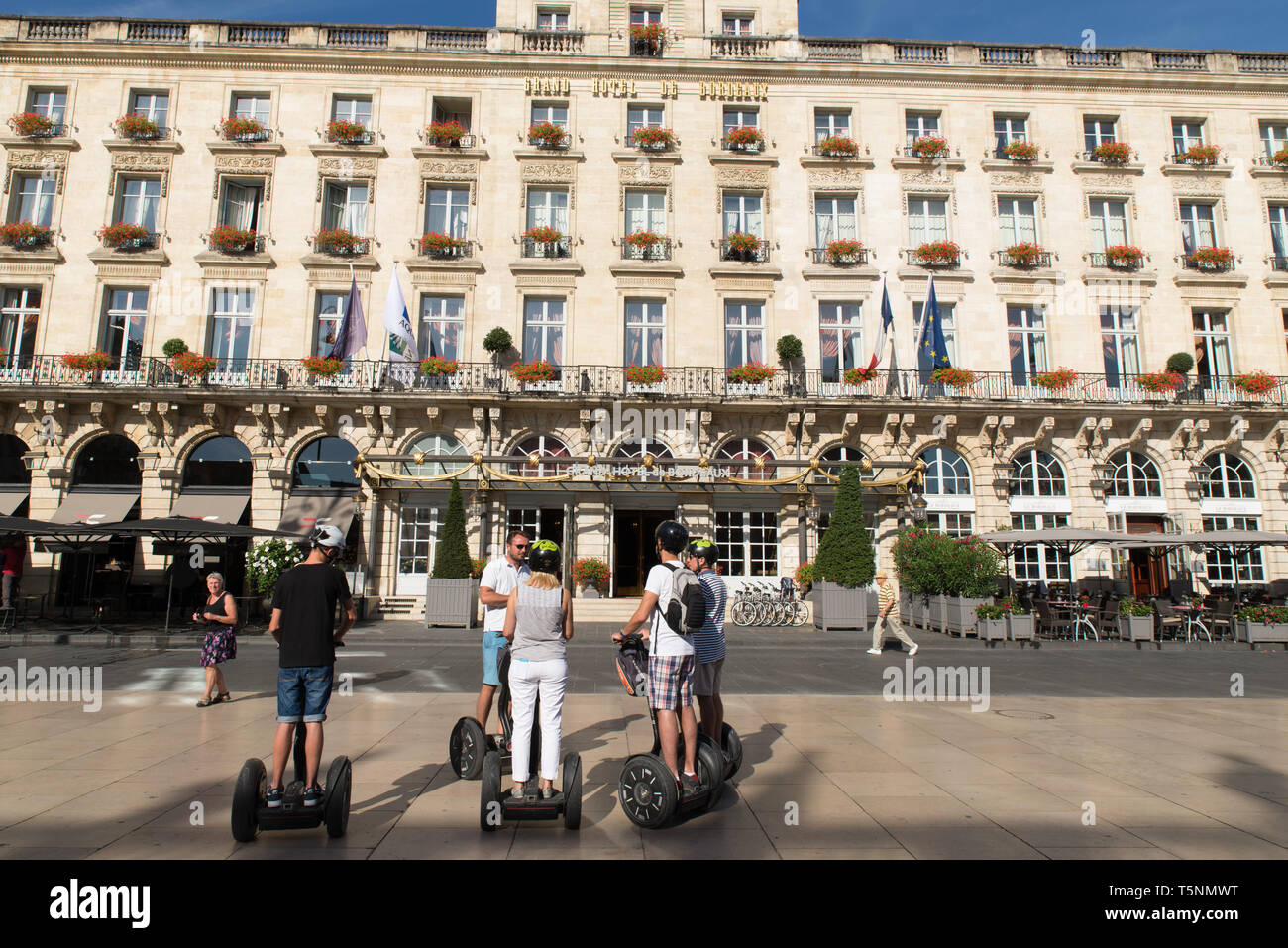 Les touristes en Sedgways devant le Grand Hôtel de Bordeaux, Gironde, France. Banque D'Images