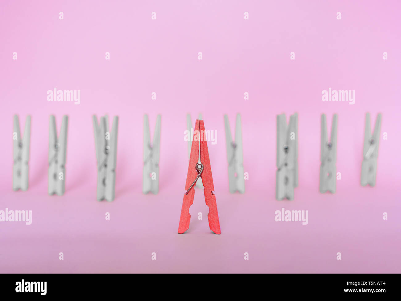 Unique, l'individualité, et pense que le leadership exceptionnel,concept différent. Clip en bois rouge se distinguent des clips incolore sur fond bleu Banque D'Images