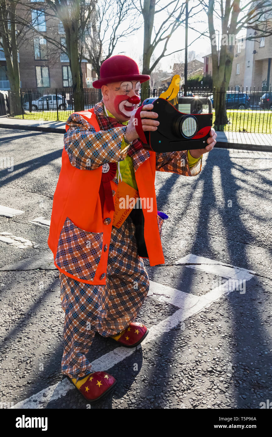 L'Angleterre, Londres, l'Assemblée annuelle de l'Église au service de clowns Grimaldi All Saints Church, West Bay, clown avec Toy Camera Banque D'Images