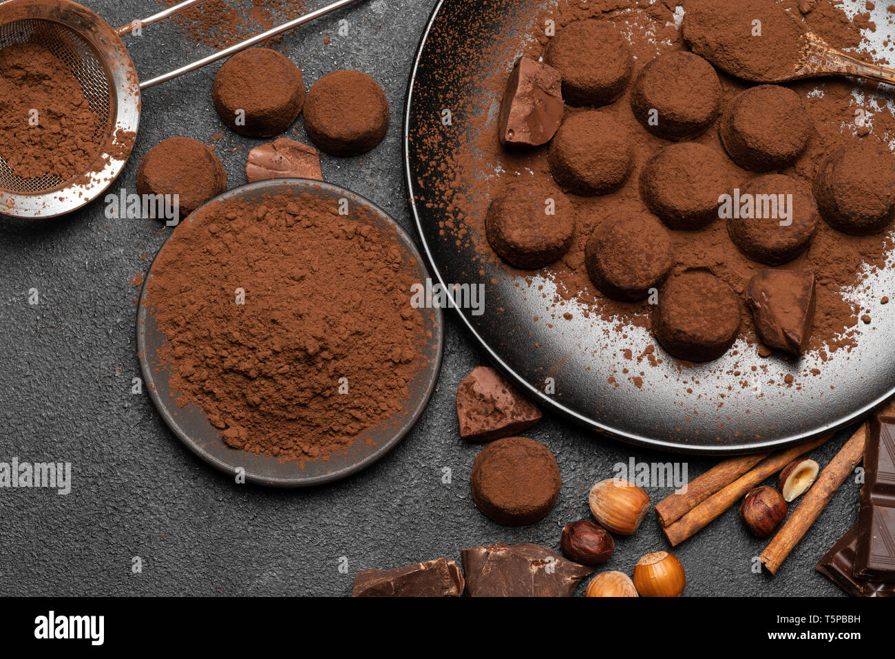 Truffes au chocolat bonbons et poudre de cacao foncé sur fond de béton Banque D'Images