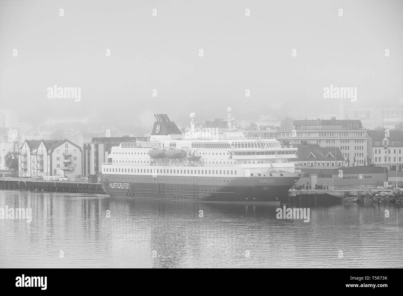 Photo en noir et blanc du navire Hurtigruten, MS NORDLYS, amarré à Harstad, dans un épais brouillard tôt le matin. Le comté de Troms, Norvège. Banque D'Images