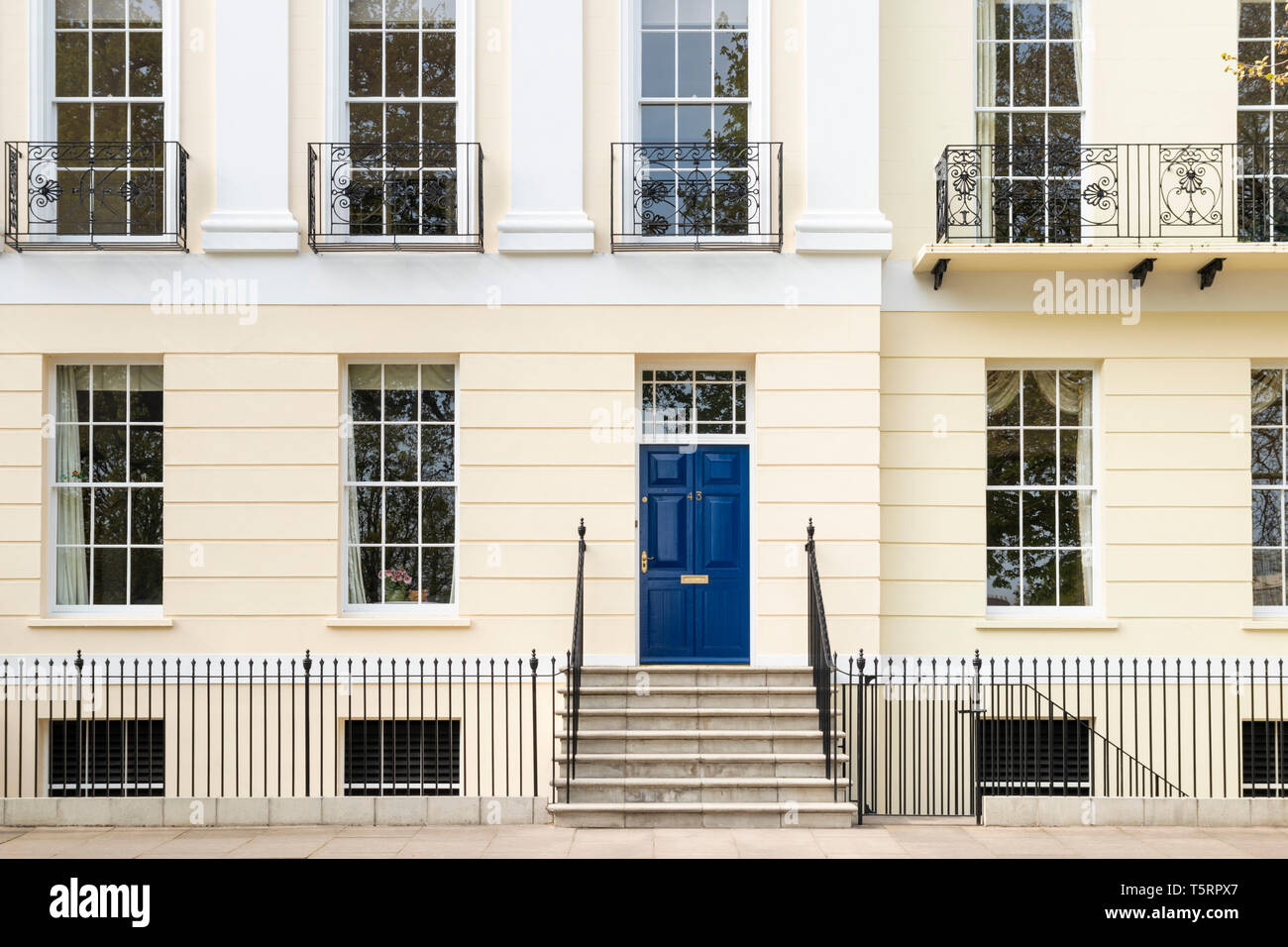Portes bleues et des balcons en fer forgé sur une terrasse de la place impériale maisons géorgiennes Gloucestershire Cheltenham Spa Angleterre GO UK Europe Banque D'Images