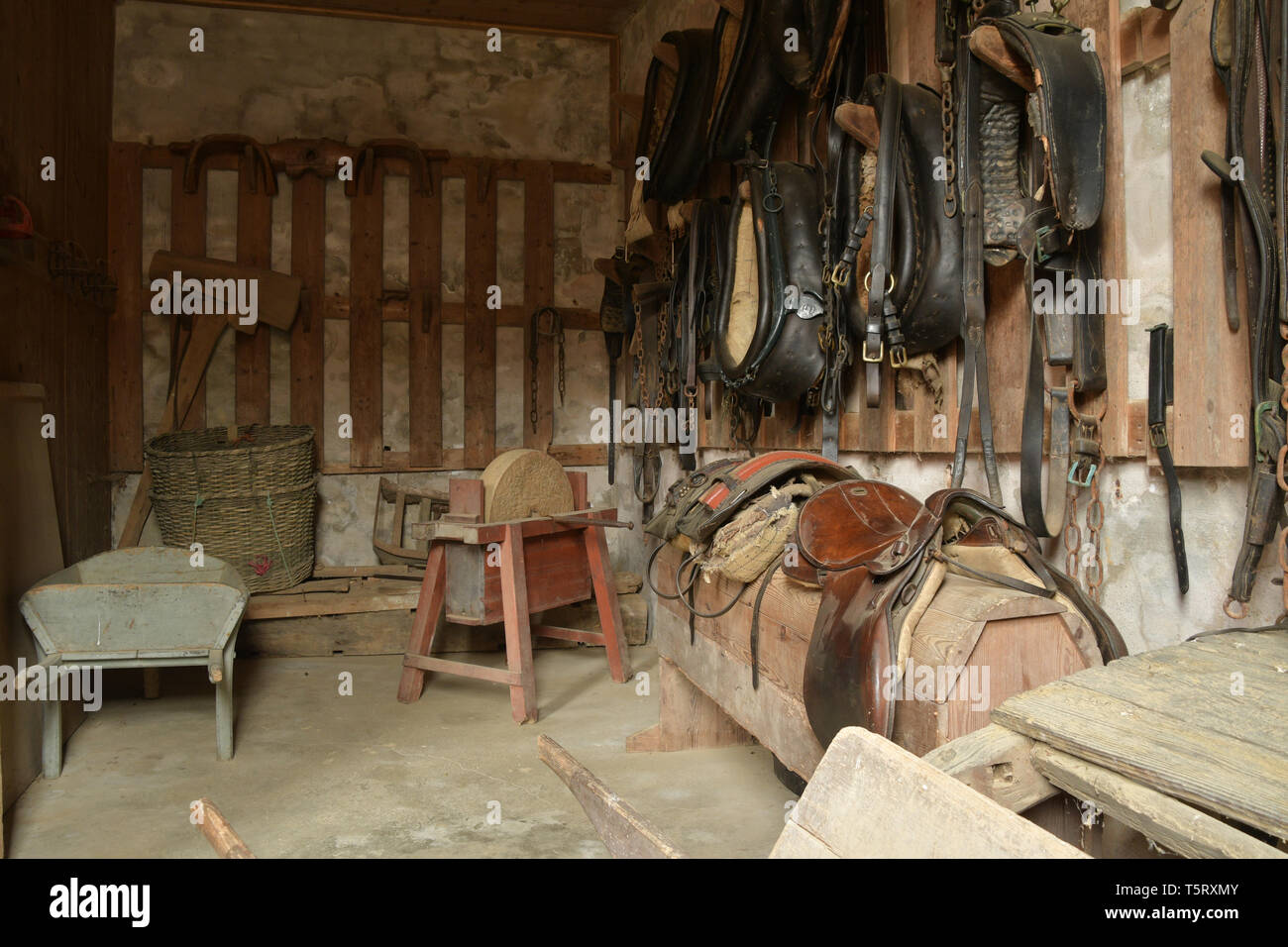 Sellerie de travail contenant des colliers de cheval,cuir,selles, brouettes et autres outils et équipements trouvés dans les écuries du milieu 18e siècle Banque D'Images