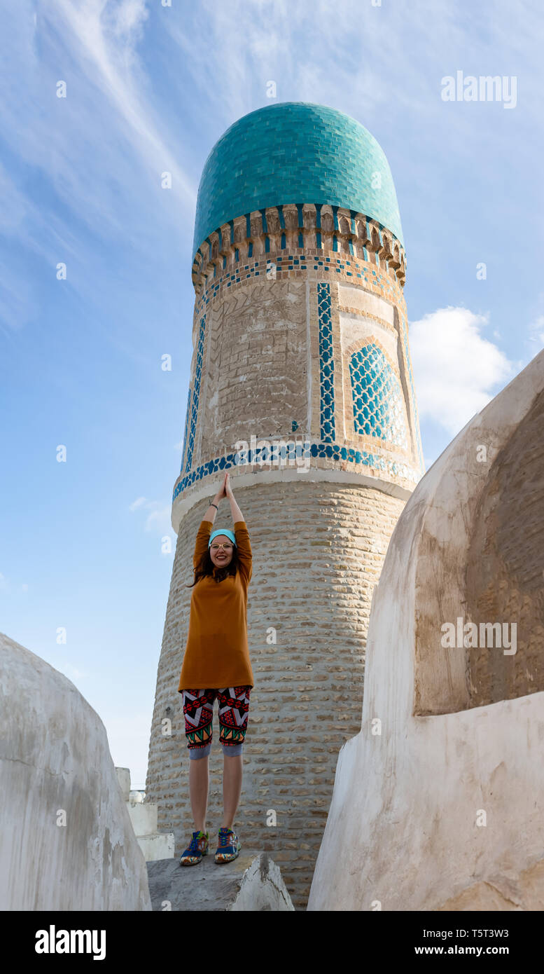 La fille sur le toit de la mosquée Chekminar - quatre minarets, dans la ville de Boukhara, Ouzbékistan. Banque D'Images