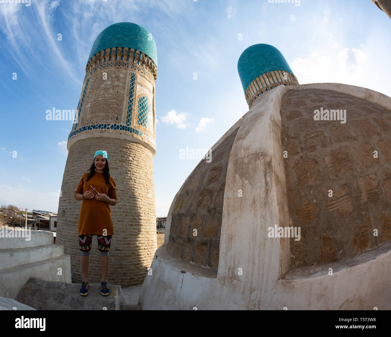 La fille sur le toit de la mosquée Chekminar - quatre minarets, dans la ville de Boukhara, Ouzbékistan. Banque D'Images