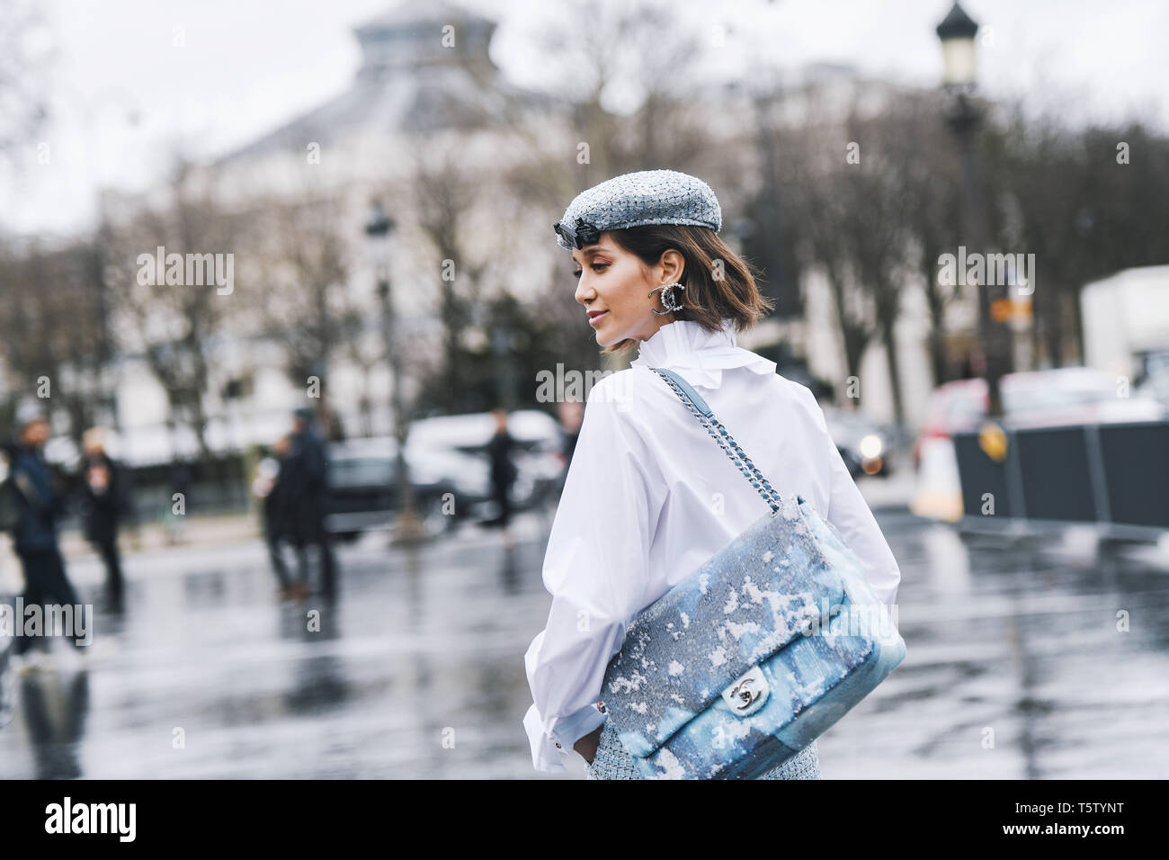 Paris, France - le 5 mars 2019 : Street style - Femme portant portant une chemise blanche, un pantalon bleu clair, noir talons, light blue hat et Chanel imprimé ba Banque D'Images