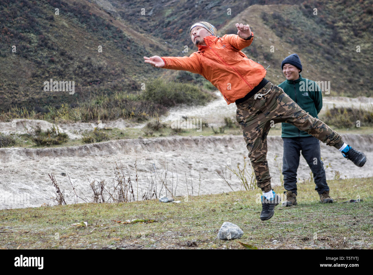 L'homme du saut et du lancer une pierre, Dego (traditionnel) jeu bhoutanais, Chozo, Lunana Gewog, Gasa District, le Bhoutan Banque D'Images